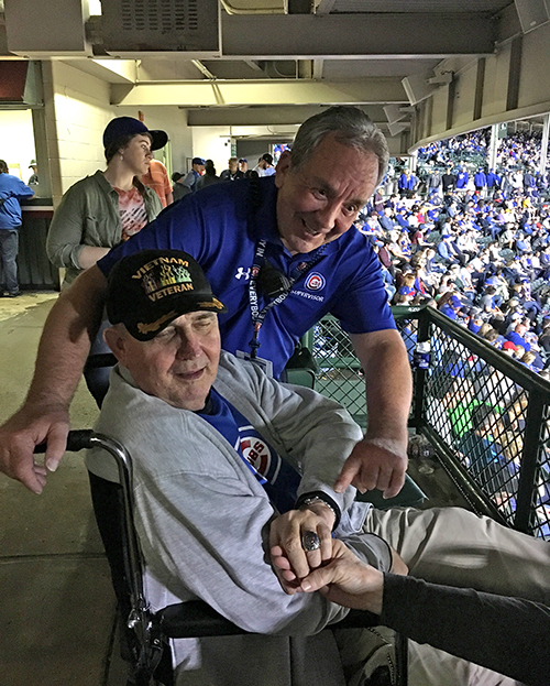 Chuck Young lets a fan at Wrigley Field wear the 2016 World Series championship ring he received while working for the Chicago Cubs.