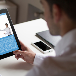 A guy holding an ipad with some courses name