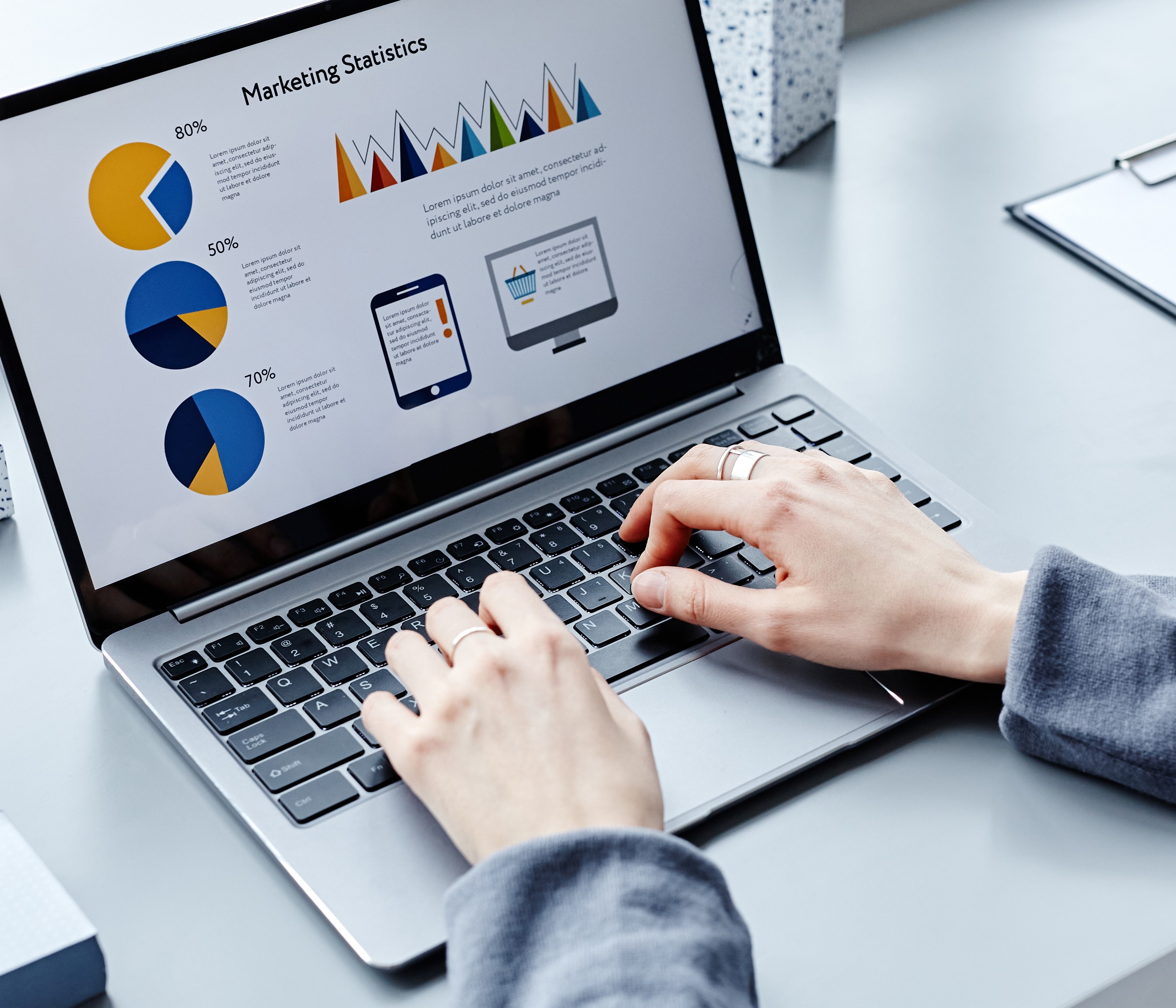 Person typing marketing statistics onto Laptop