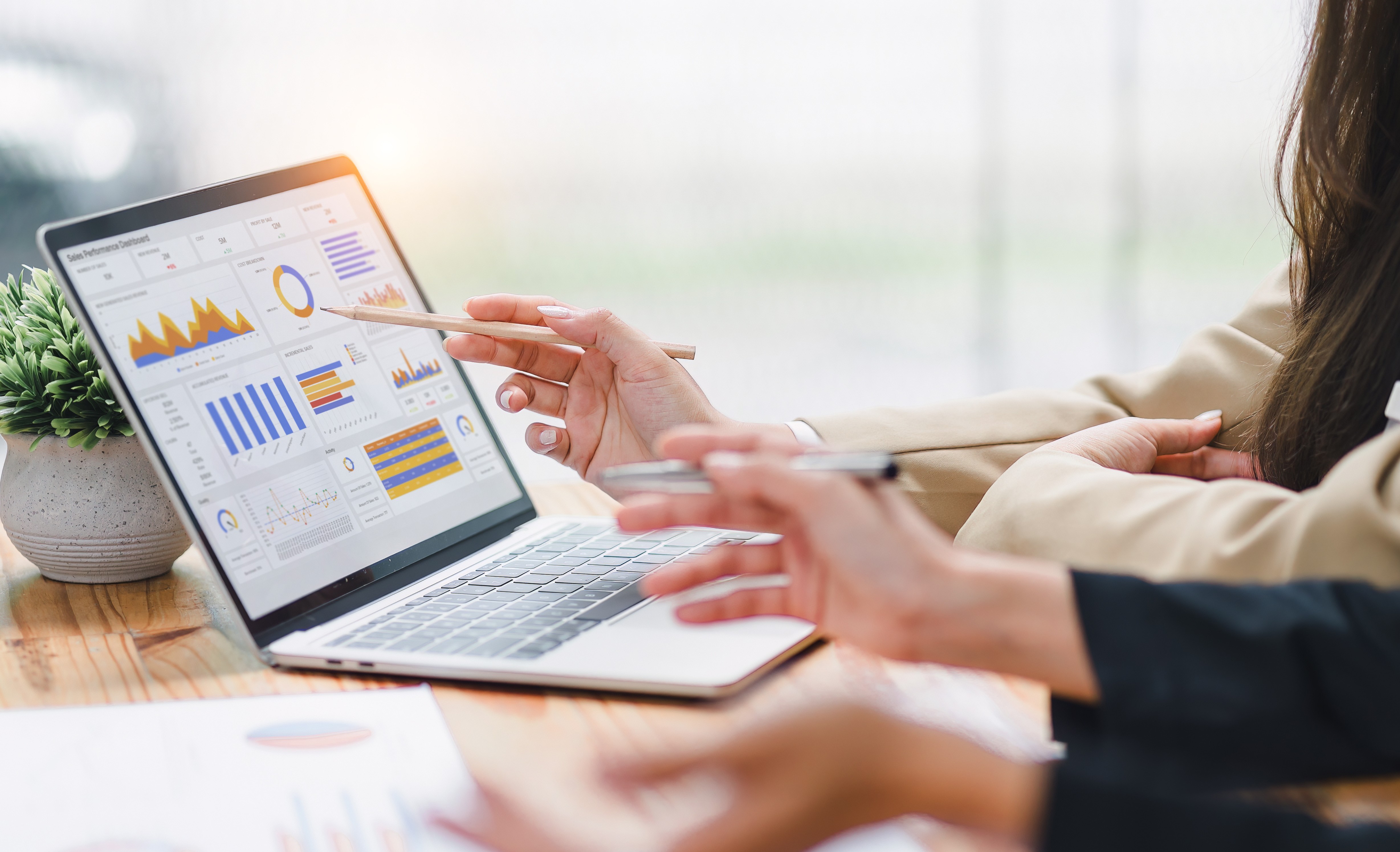 Two people reading analytics on laptop