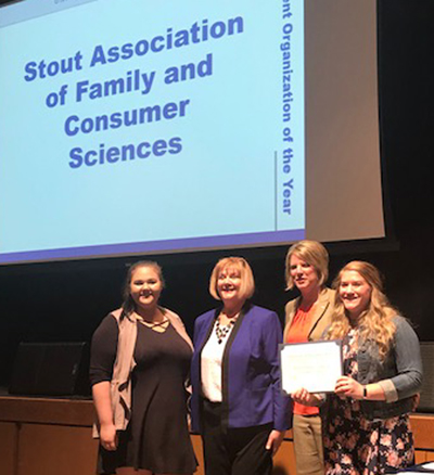 Students Afton Fischer, left, and Kyla Bergstrom, right accept the Outstanding Student Organization award from associate deans Carol Johnson, second from left, and Kristal Gerdes.