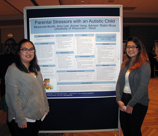 Aimee Vang, left, and Amy Lee present research on the stress felt by parents of an autistic child.