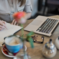 planning content on a book with an open laptop