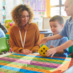 A teacher watching two kids playing