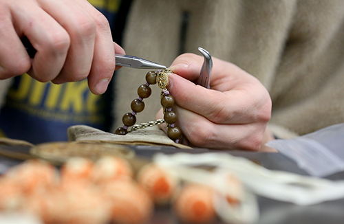 Jared LeClaire Jr. works on a necklace for the Radical Jewelry Makeover