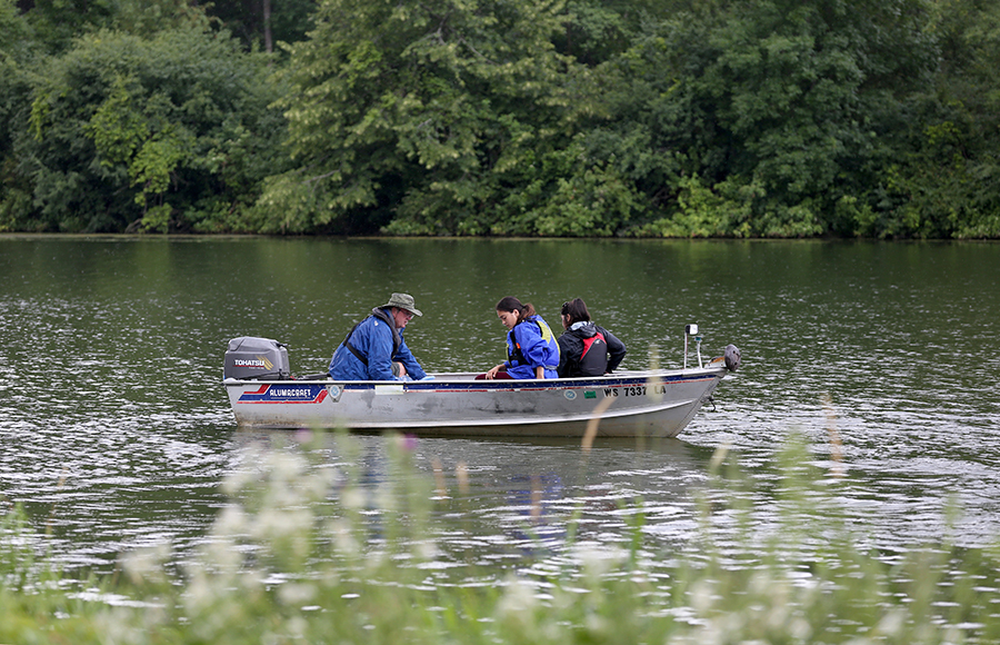 LAKES REU student collect water samples on Lake Menomin.