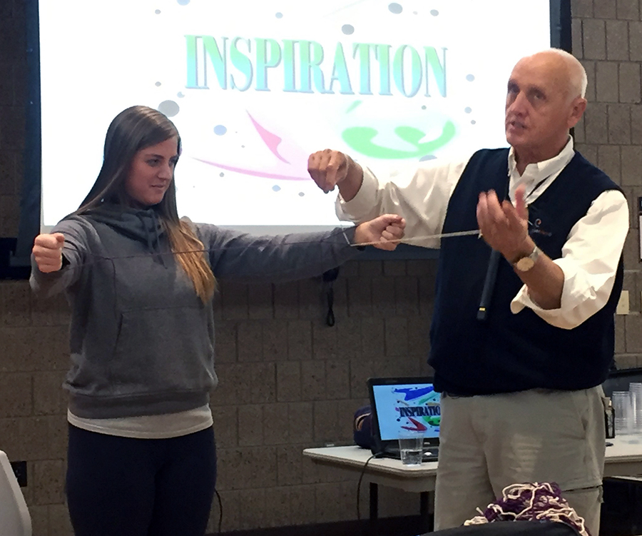 Olson, at right, with Borman, demonstrates how to work together to get yarn strings untangled. Olson uses magic and sleight of hand tricks to engage listeners and give them mental breaks.