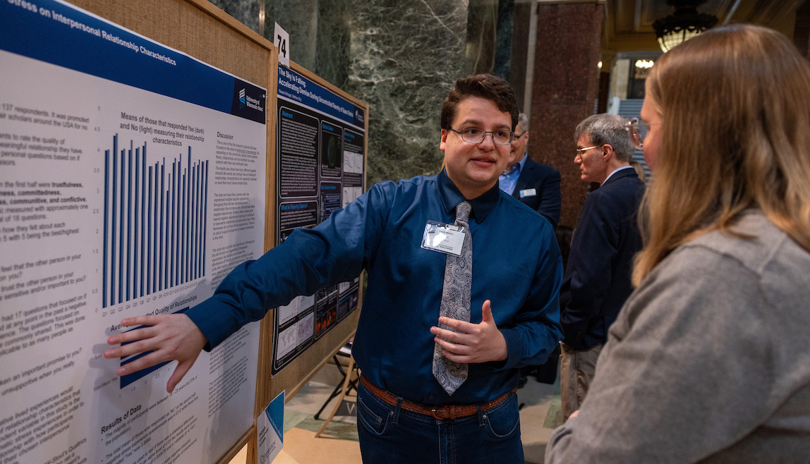 A Stout student presents his research in the Madison Capitol building during Research in the Rotunda.