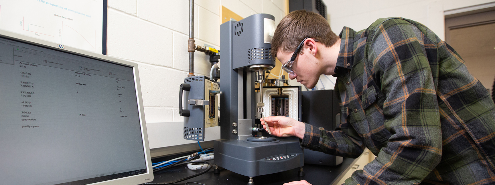 Student performs a stress test in the plastics engineering lab.