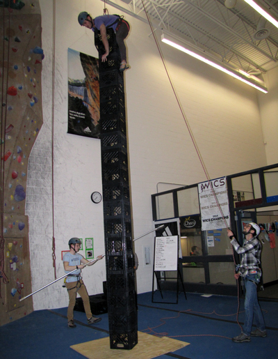 Student Devon Manuele stands on about 20 of the eventual 23 milk crates he stacked while harnessed during a competition at Stout Adventures. The free event encourages students to try climbing. 