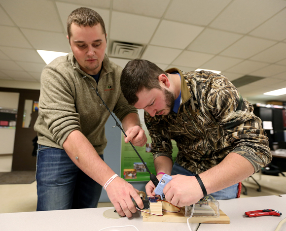Drew Merryfield, left, and Bryan Lammers set up their ice fishing invention, a pole that automatically jigs for fish and reels them in. 