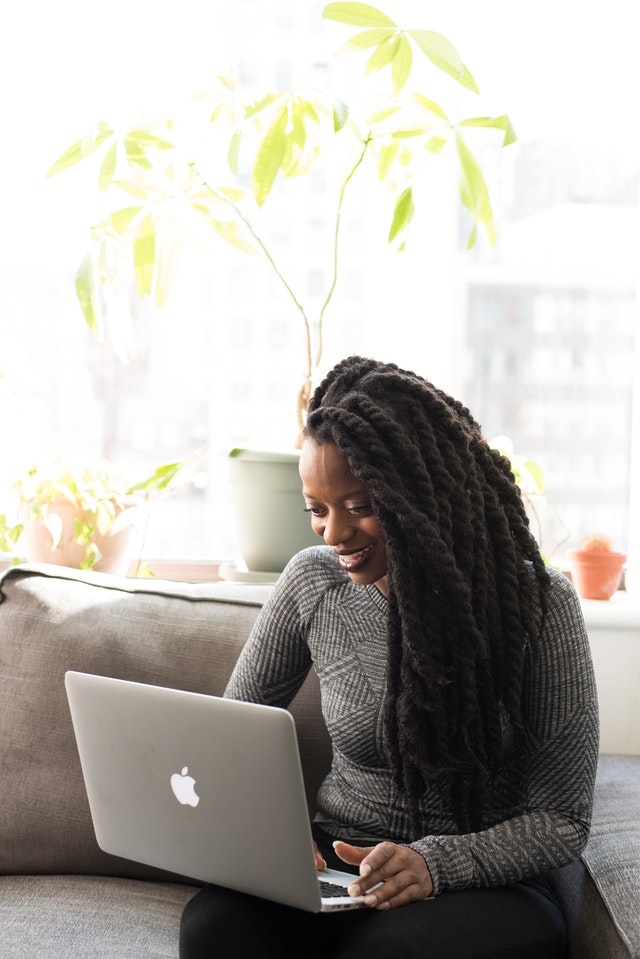 person sitting on couch looking at laptop