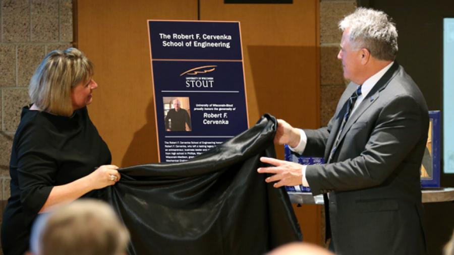 A friend of the Cervenka family, Leslie Lagerstrom, left, unveils a plaque with Chancellor Bob Meyer for the Robert F. Cervenka School of Engineering at a dedication ceremony Friday, Oct. 27, at UW-Stout.