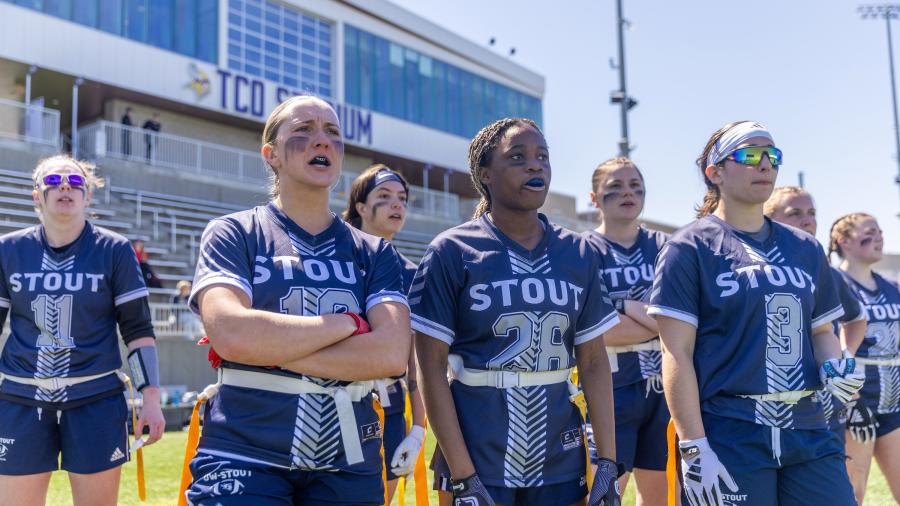 Blue Devil players watch from the sidelines during the inaugural Blue Devil Anna Mutch runs the ball during the inaugural Midwest College Women’s Flag Football League Championship.