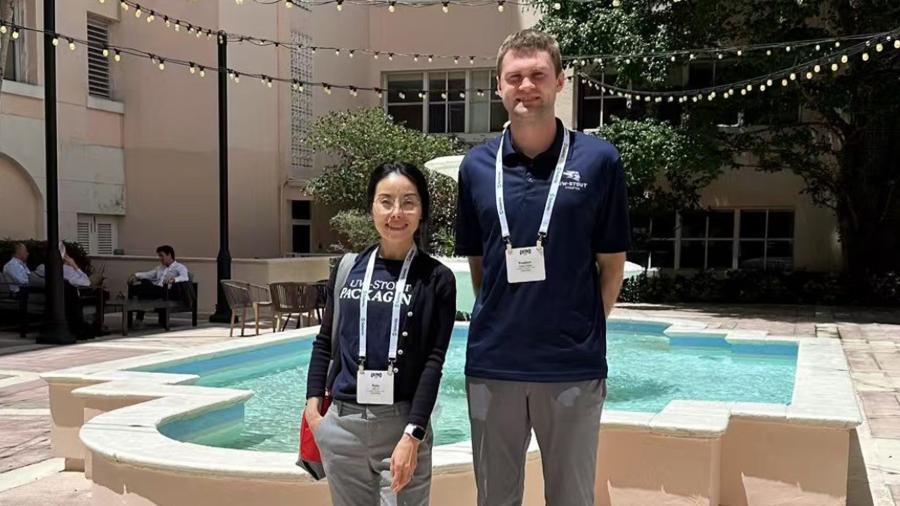 Two people stand in a hotel courtyard in front of a fountain.