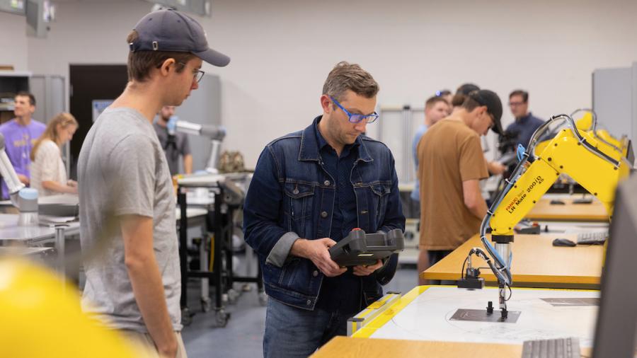 Students program software for robotic arms in an automation lab
