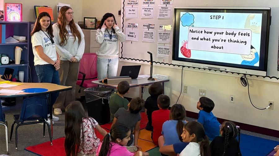 School psychology students talk with an elementary classroom