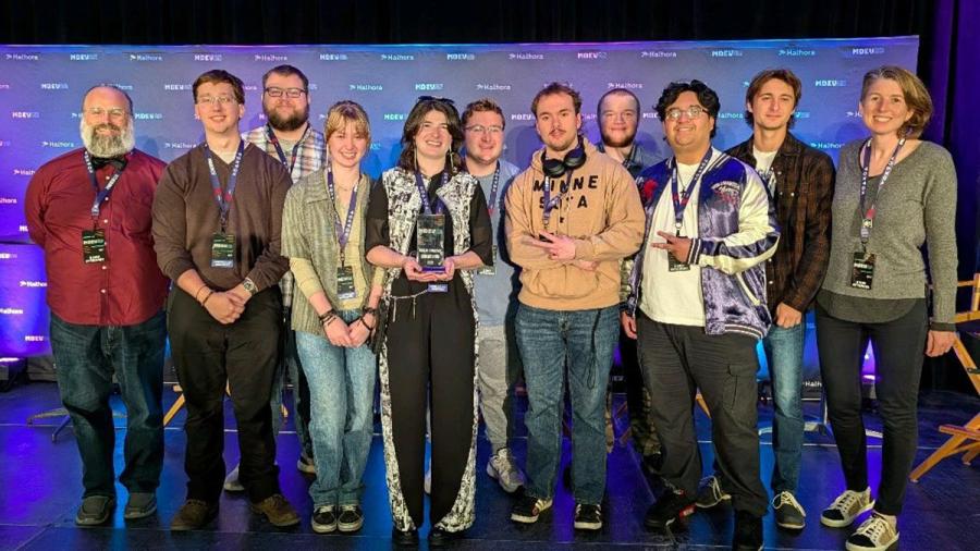 People on stage with trophy