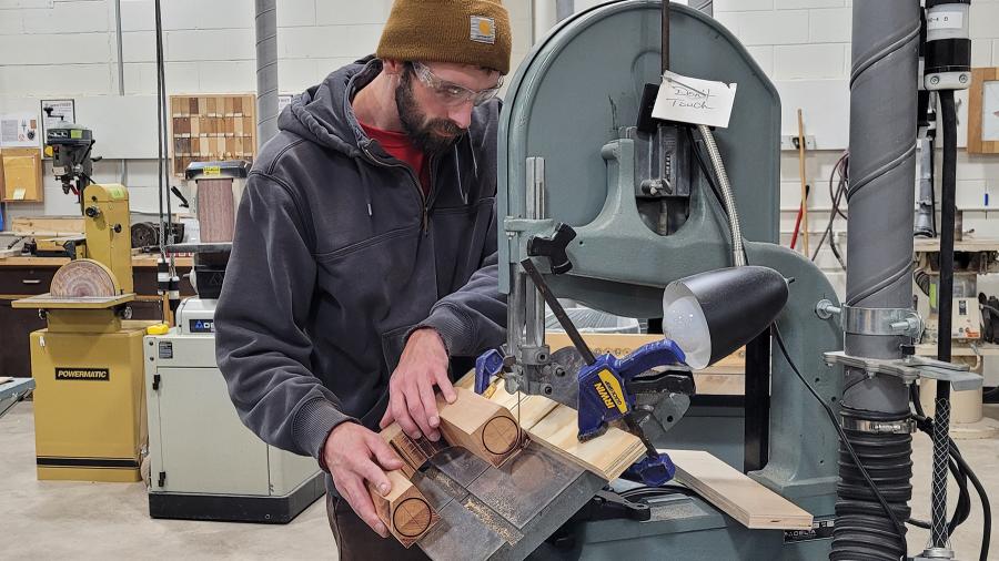 An industrial design student uses a band saw in the Process Lab.