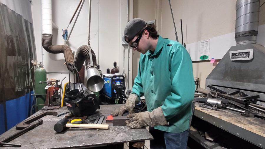An industrial design student welding a T-bar.