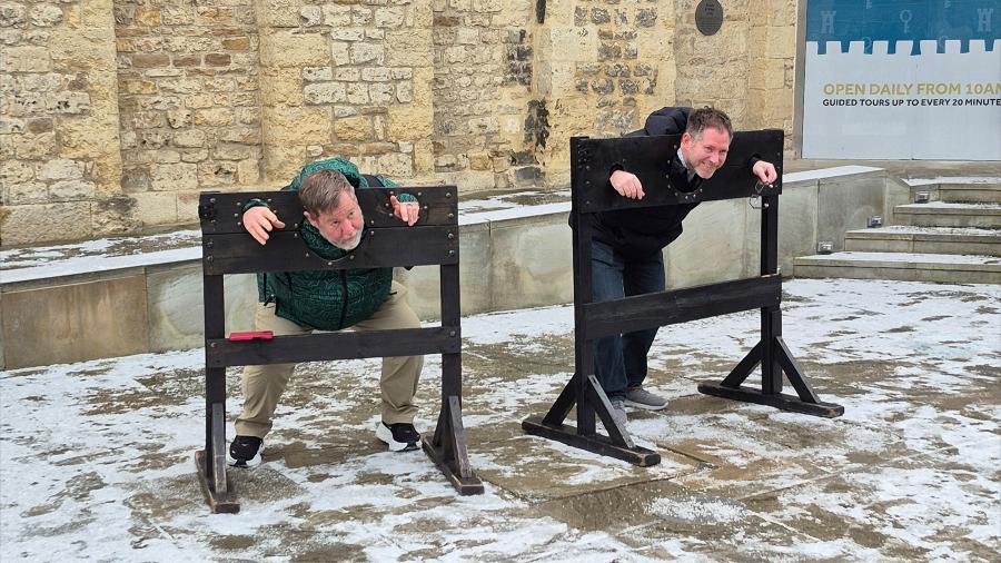 Two professors are locked in the pillory as they pose for a photo Oxford castle and prison