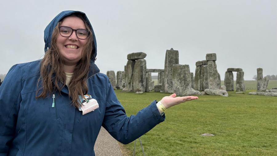 A student pretends to hold Stonehenge in the palm of her hand