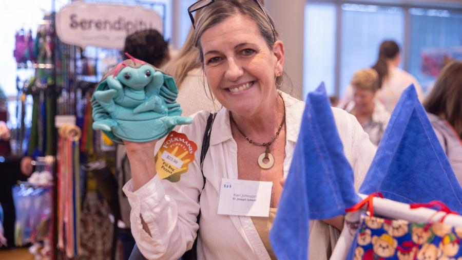 A teacher holds a puppet at an educational vendors fair