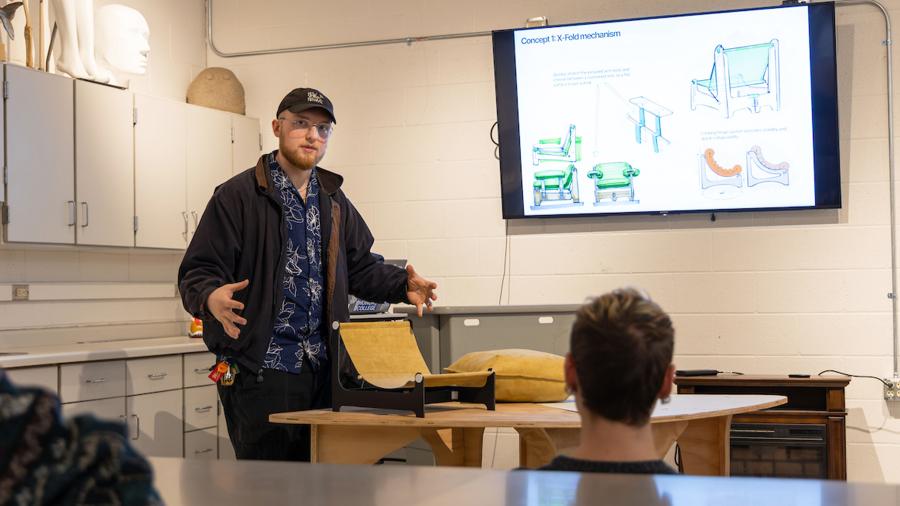 Aaron Hoyt presents his prototype of a collapsible chair in a class critique.