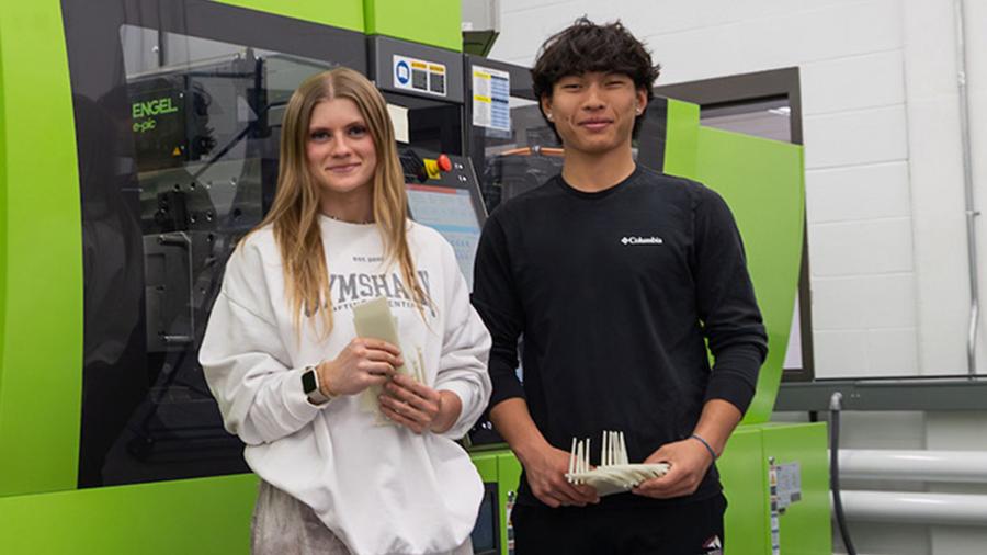 Student research assistants with injection molding machine