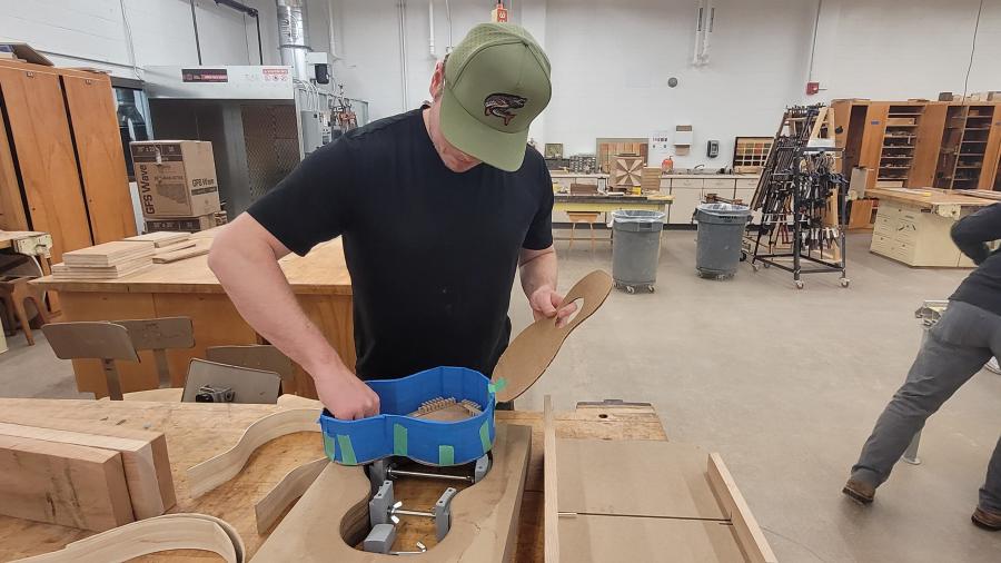 Konnor Kraft shows a cardboard prototype and the CNCed jig for a ukulele