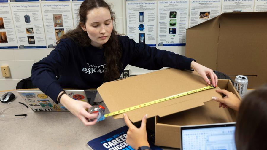 Woman measuring cardboard