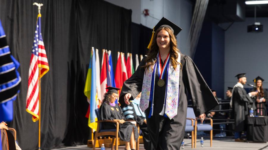 Kloie Potts crosses the commencement stage at graduation
