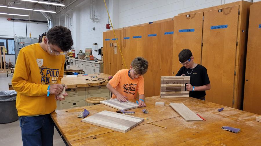 STEAM Construction campers sanding their cutting boards