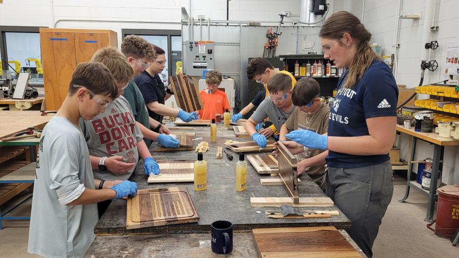 STEAM Construction campers and instructors sealing their cutting boards