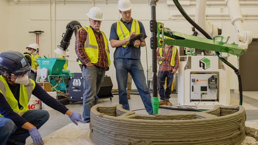 A Stout instructor and student in the 3D Concrete Printing Certificate program oversee production of a test concrete wall.
