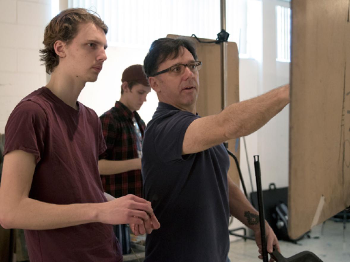 Assistant Professor Daniel Atyim, right, works with a student in a Drawing II class in February.