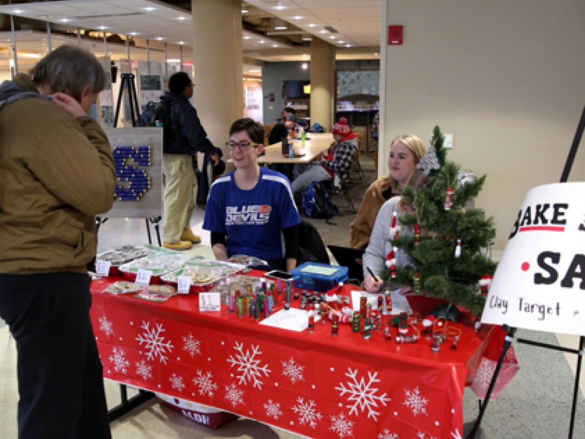 Members of the new Clay Target Club at UW-Stout, including President Emma Kosanke, second from left, sell holiday crafts made of used shotgun shells Tuesday, Dec. 5, at the Memorial Student Center.