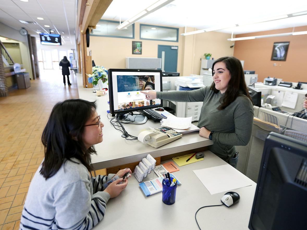Lorrie Luepke assists student Kagai Vang at Student Business Services.
