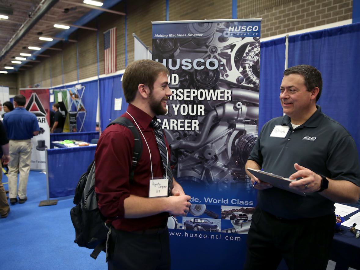 Pictured is engineering technology student August Jorgensen speaking with a representative at the Husco Automotive booth.