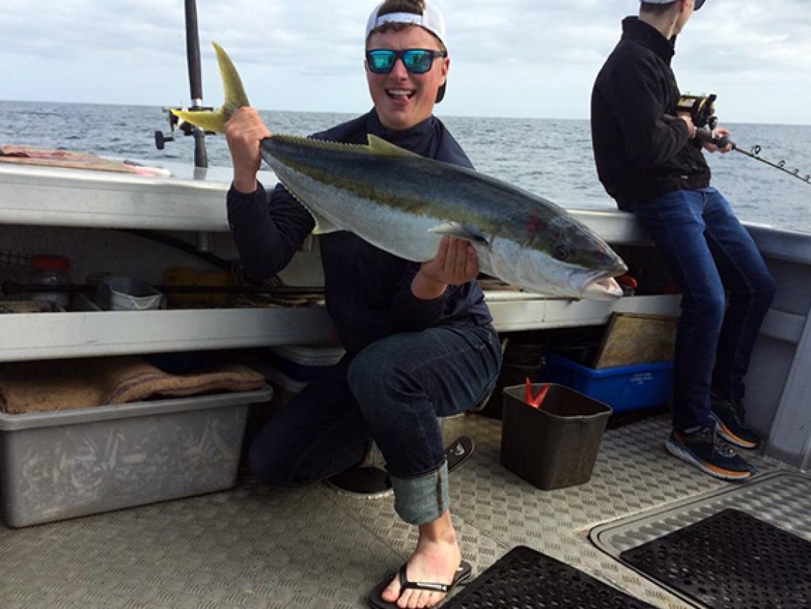 Sam Klobucar shows off a kingfish he caught while in New Zealand.