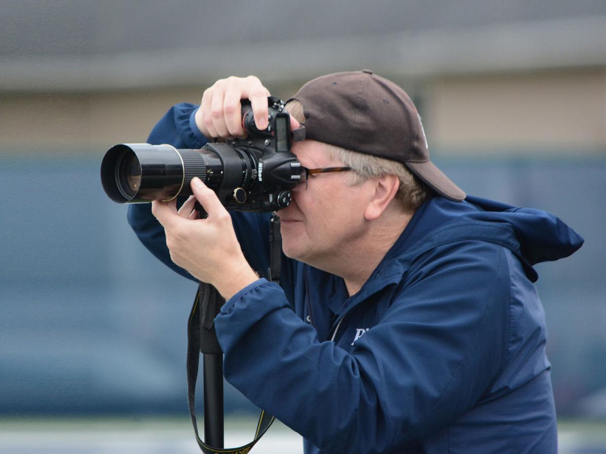 Layne Pitt, UW-Stout’s sports information director, takes photos at a football game. Pitt received a 25-year-award recently from the College Sports Information Directors of America.