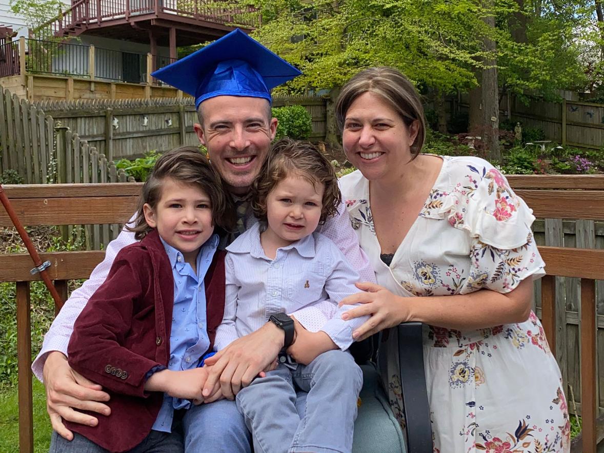 Josh Hellenbrand, management graduate, with his family at their home in Baltimore.