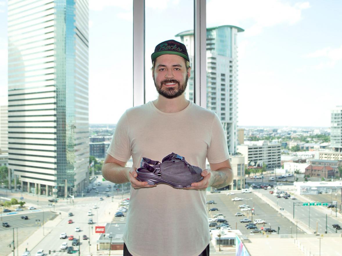 Alexander Mayhew, industrial design graduate, with a pair of Crocs shoes he designed.