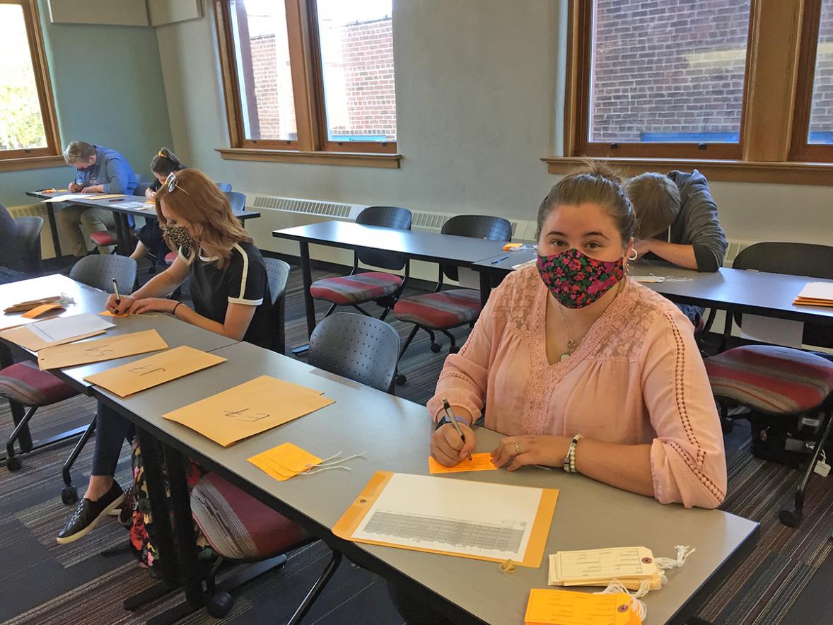 UW-Stout student Katie Ferguson fills out toe tags to be part of an art exhibit at the University Library. The tags represent migrants who have died trying to cross the Sonoran Desert to come to the U.S.