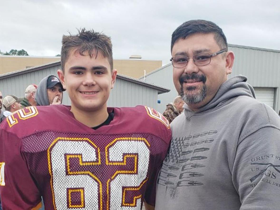 Adam Richards, supply chain management graduate, and his son at a Menomonie Mustangs game.