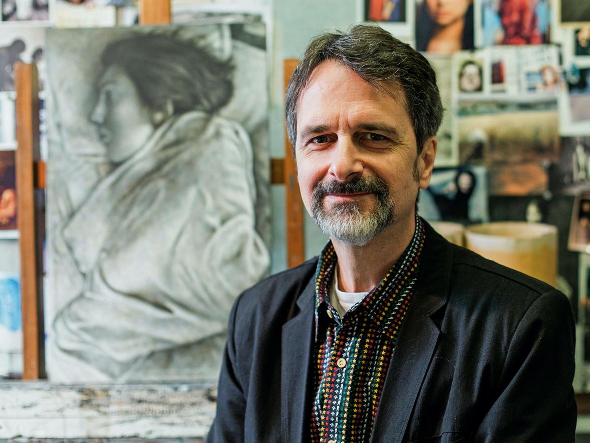 Artist Tim Lowly, of Chicago, stands in his studio near a painting that depicts his daughter, Temma, who has cerebral palsy. / Leah Emerson photo