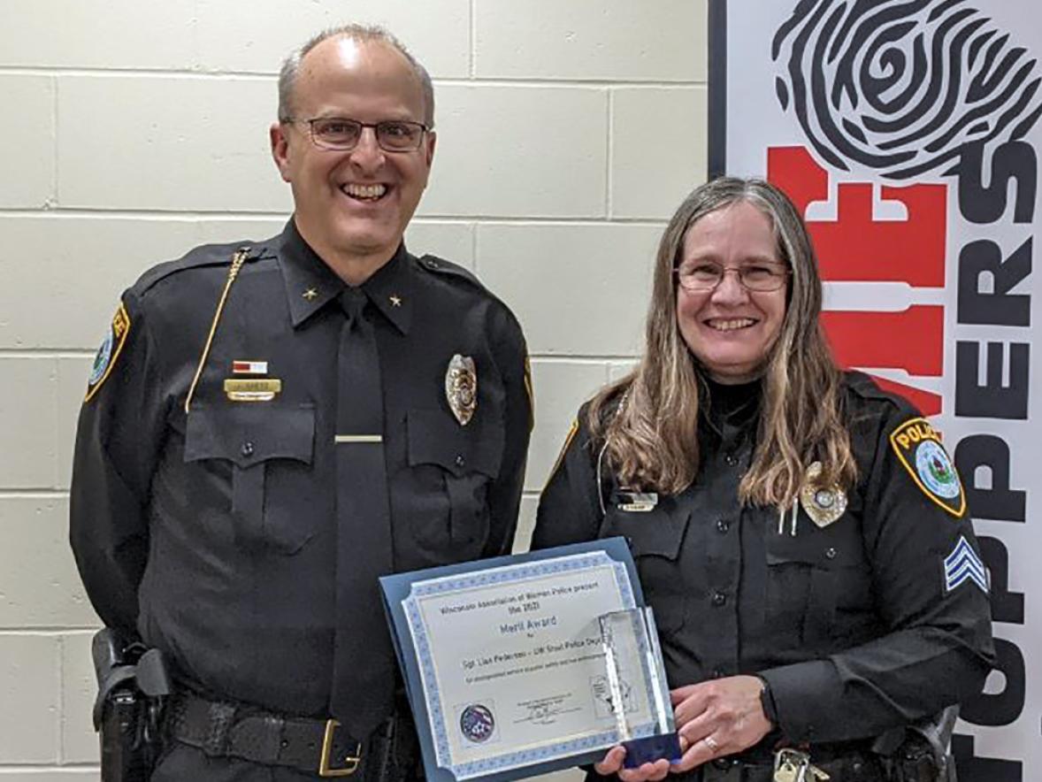 Sgt. Lisa Pederson of the UW-Stout police holds her merit award from the Wisconsin Association of Women Police alongside Chief Jason Spetz, who nominated her.