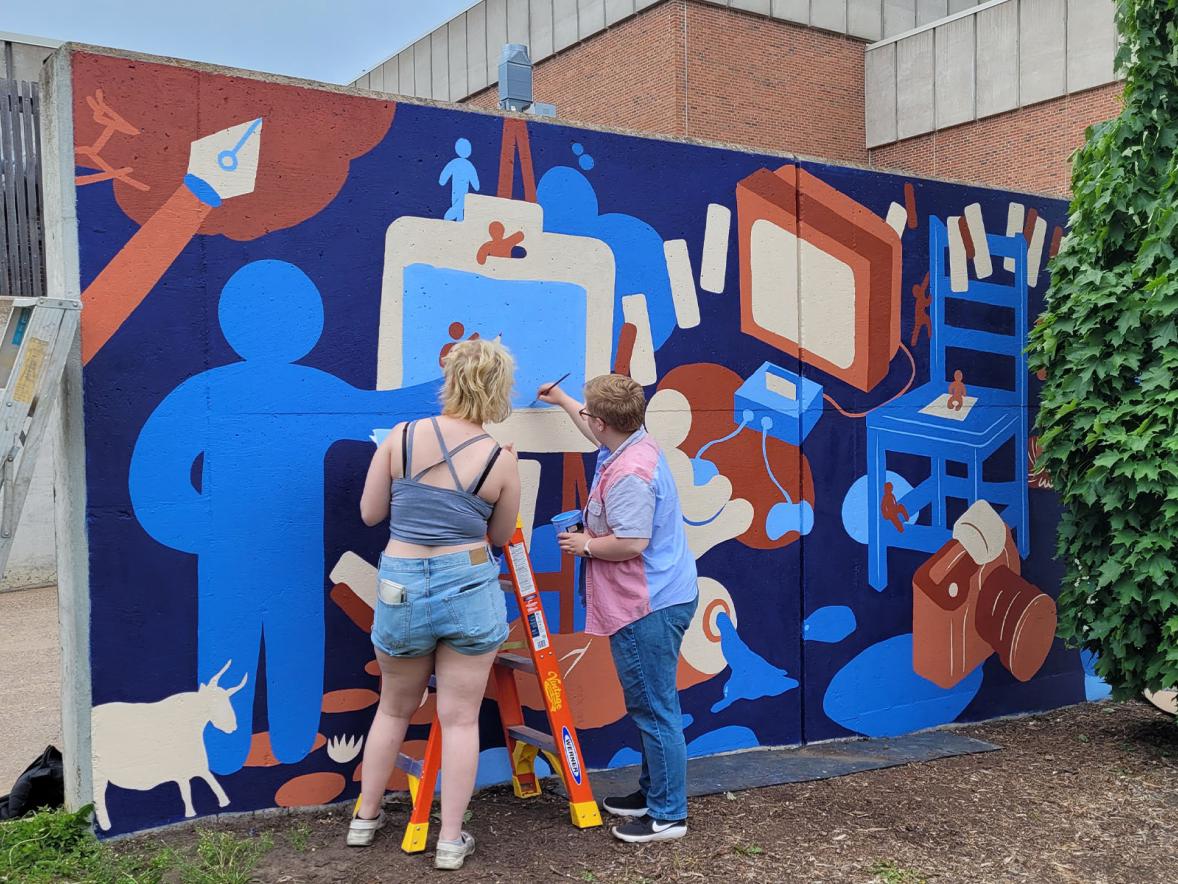 Graffiti and Street Art students adding finishing touches to the mural.
