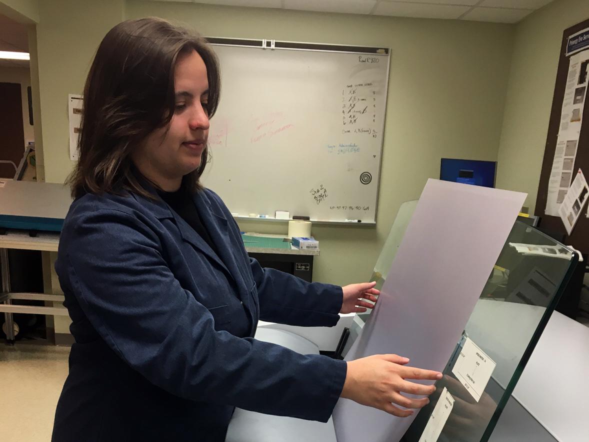 Cali Scholes, a graphic communications major, inserts an offset printing plate into a Kodak computer-to-plate imaging device in a UW-Stout lab.