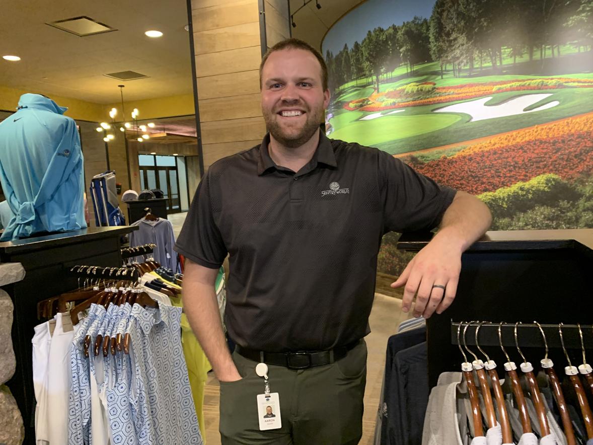 Saari works from the SentryWorld pro shop, which features a mural of the course’s Flower Hole, in the background.